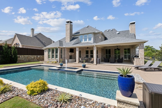view of pool featuring fence, a pool with connected hot tub, a patio, and ceiling fan