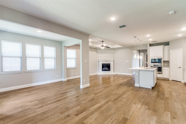 1624 Sweetwater Way, Celina, TX 75009 - unfurnished living room featuring light wood finished floors, a ceiling fan, a fireplace, and recessed lighting