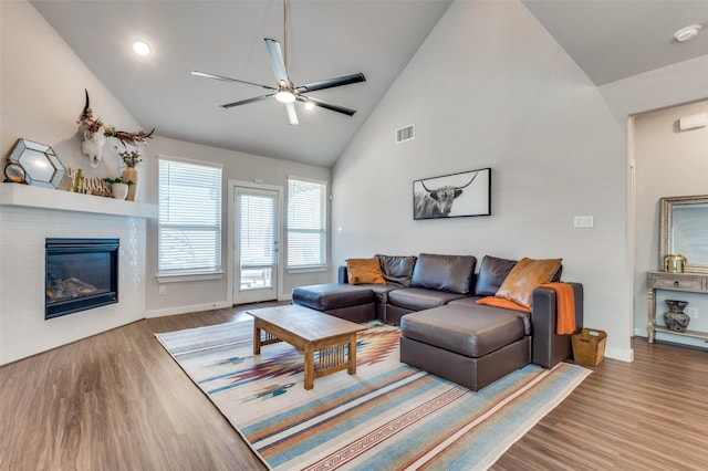 4737 Tanglewood Dr, Haltom City, TX 76137 - living room with a glass covered fireplace, a ceiling fan, visible vents, high vaulted ceiling, and wood finished floors