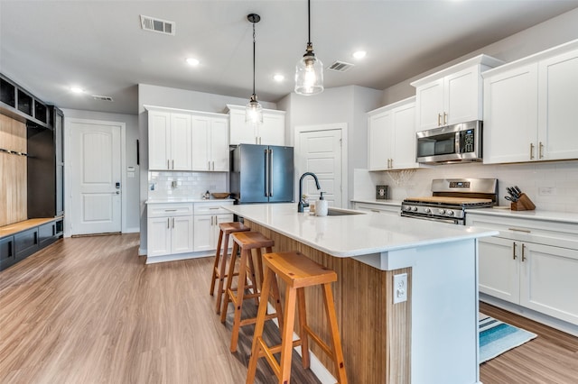 4737 Tanglewood Dr, Haltom City, TX 76137 - kitchen with a breakfast bar area, appliances with stainless steel finishes, a sink, and visible vents