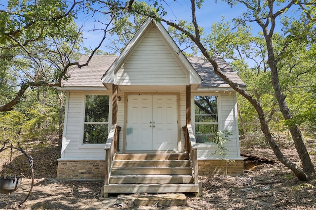 view of front of house featuring entry steps and a shingled roof