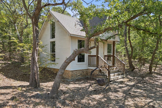 exterior space with roof with shingles