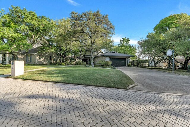 view of front facade featuring a front lawn, fence, a garage, and aphalt driveway