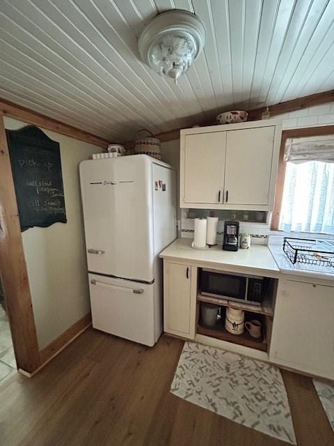 239 Ranch Rd, Joshua, TX 76058 - kitchen with freestanding refrigerator, wood ceiling, stainless steel microwave, wood finished floors, and light countertops