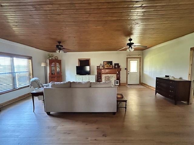 living room with wood ceiling, a ceiling fan, and a healthy amount of sunlight