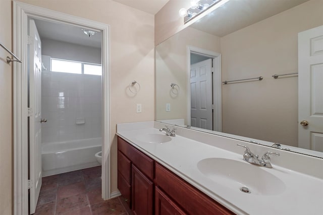 bathroom with a sink, toilet, double vanity, and shower / bathing tub combination