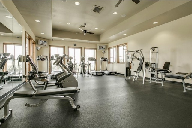 gym featuring visible vents, ceiling fan, recessed lighting, and a tray ceiling
