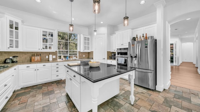 kitchen featuring tasteful backsplash, appliances with stainless steel finishes, and stone tile flooring
