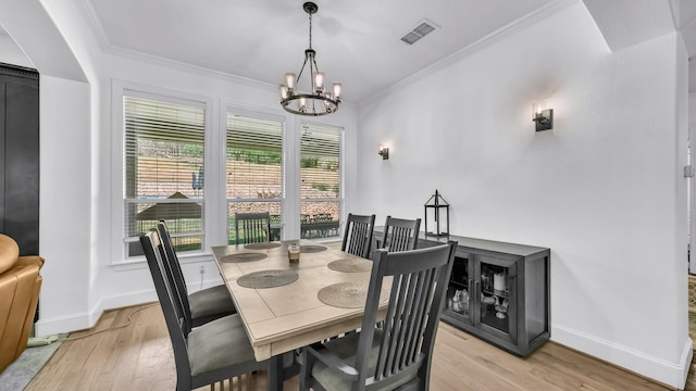 dining area featuring light wood-style flooring, baseboards, and an inviting chandelier