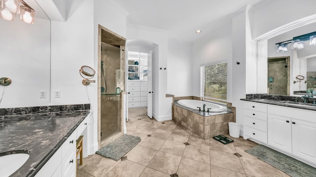 bathroom with two vanities, tile patterned floors, a garden tub, a shower stall, and a sink