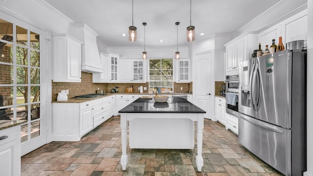 kitchen with stainless steel fridge with ice dispenser, custom exhaust hood, stone tile flooring, white cabinetry, and decorative backsplash