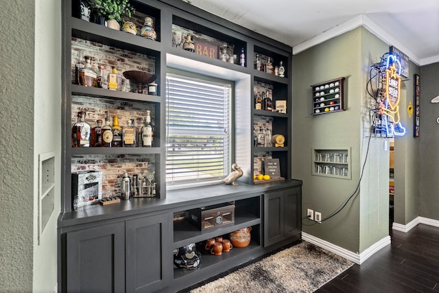 bar with baseboards, built in features, a textured wall, a dry bar, and dark wood finished floors
