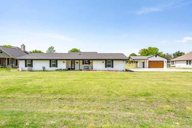 ranch-style house with an outbuilding, a detached garage, a front lawn, and concrete driveway