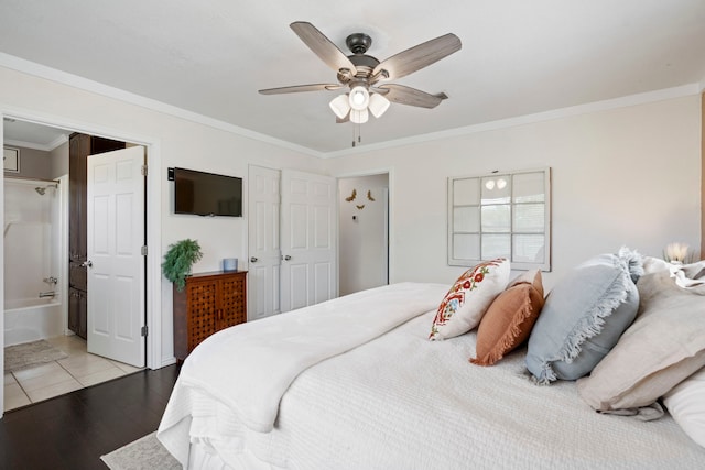 bedroom featuring connected bathroom, light wood-type flooring, crown molding, and a ceiling fan