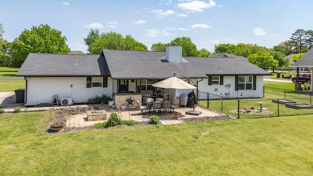 rear view of property featuring a patio, a chimney, brick siding, a yard, and fence