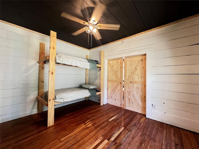 143 Lisa Layne St, Gun Barrel City, TX 75156 - unfurnished bedroom with hardwood / wood-style flooring, wood walls, and a ceiling fan