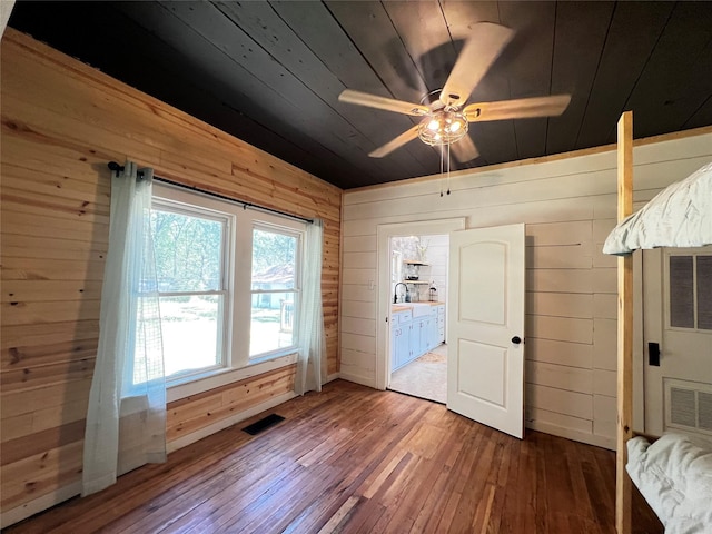 143 Lisa Layne St, Gun Barrel City, TX 75156 - unfurnished bedroom featuring wood walls, hardwood / wood-style flooring, wood ceiling, and a ceiling fan