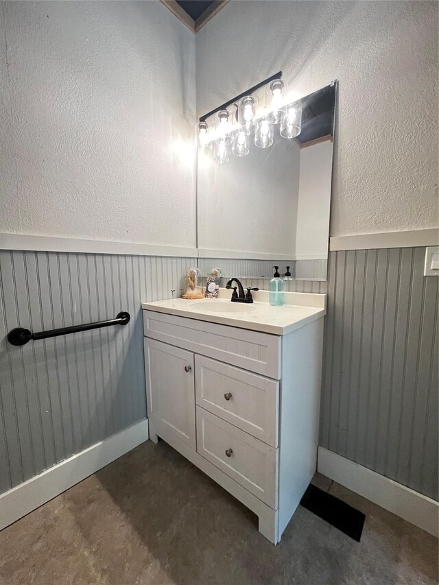 143 Lisa Layne St, Gun Barrel City, TX 75156 - bathroom featuring vanity, a wainscoted wall, a textured wall, and concrete floors
