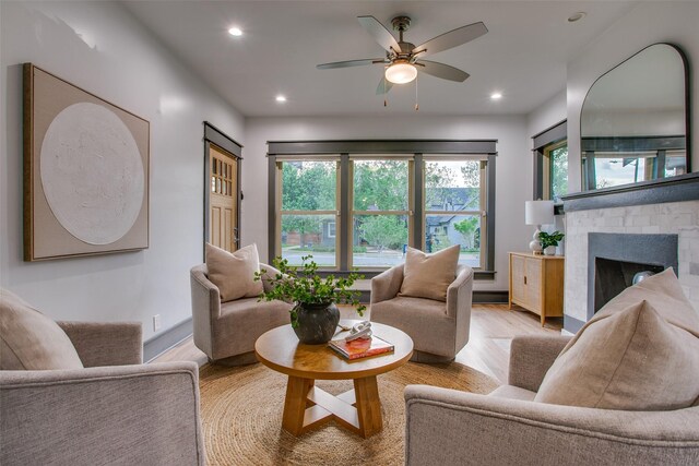 living room featuring wood finished floors, ceiling fan, a fireplace, and recessed lighting