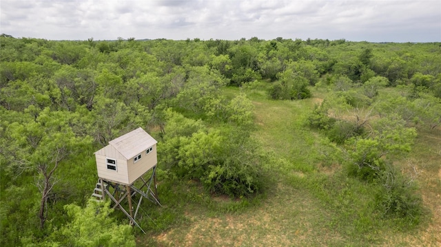 birds eye view of property featuring a view of trees