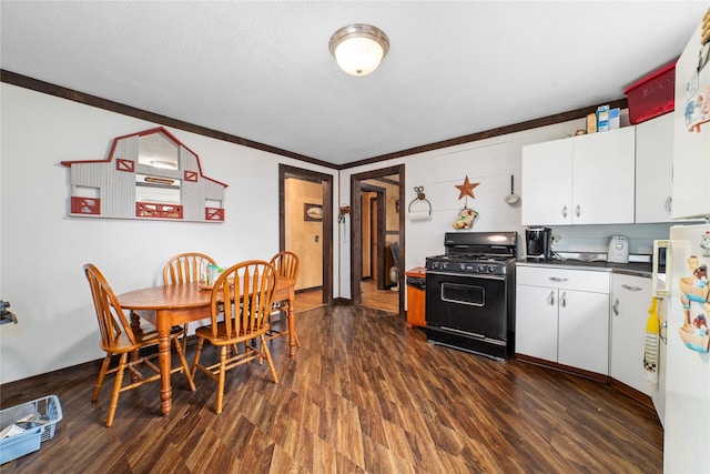 kitchen featuring freestanding refrigerator, white cabinets, dark wood-style flooring, dark countertops, and black gas stove