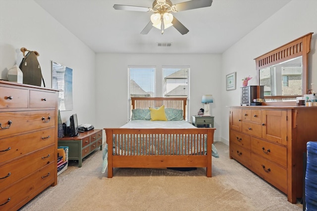 bedroom with multiple windows, visible vents, a ceiling fan, and light carpet