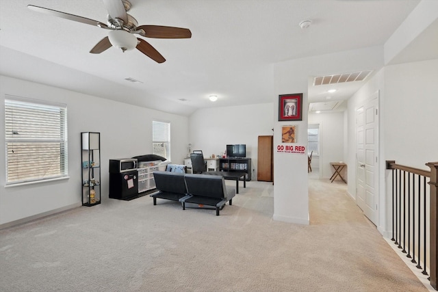 office space with a ceiling fan, visible vents, and light colored carpet