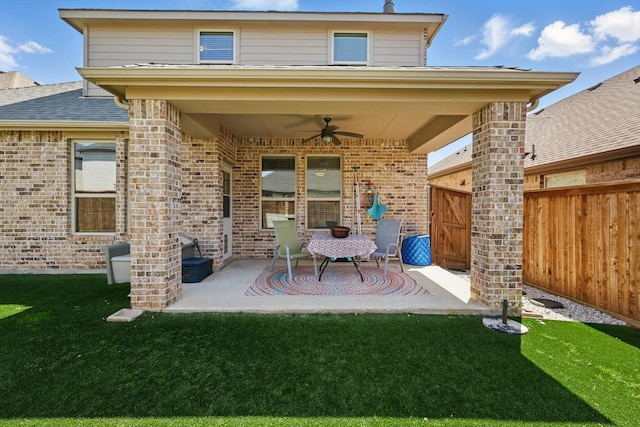 exterior space featuring brick siding, a ceiling fan, a patio area, and fence