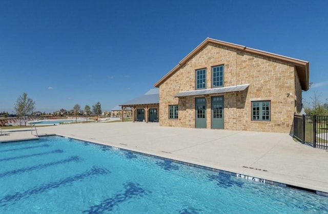 community pool featuring fence and a patio