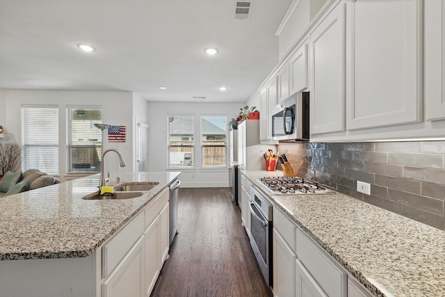 kitchen featuring dark wood finished floors, stainless steel appliances, visible vents, a sink, and white cabinetry