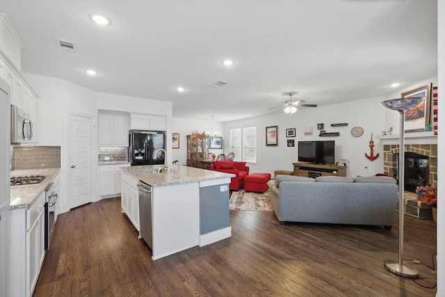 kitchen with open floor plan, ceiling fan, stainless steel appliances, dark wood-type flooring, and visible vents