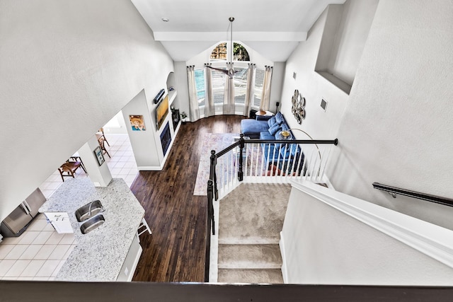 stairway featuring baseboards, wood finished floors, a fireplace, and lofted ceiling