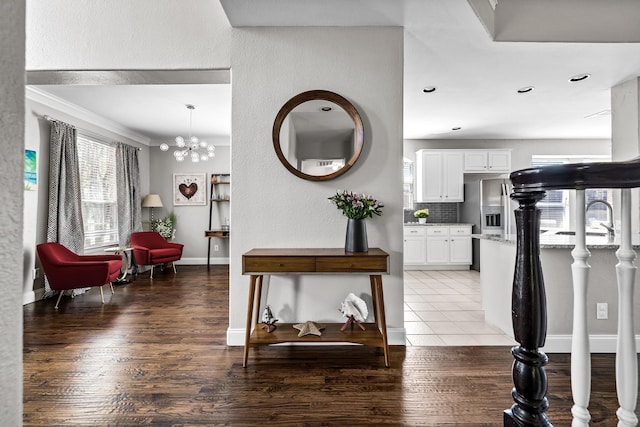 interior space with a chandelier, light wood-type flooring, baseboards, and ornamental molding