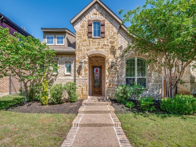 915 Enchanted Wood Dr, Arlington, TX 76005 - french country style house featuring stone siding, brick siding, and a front yard