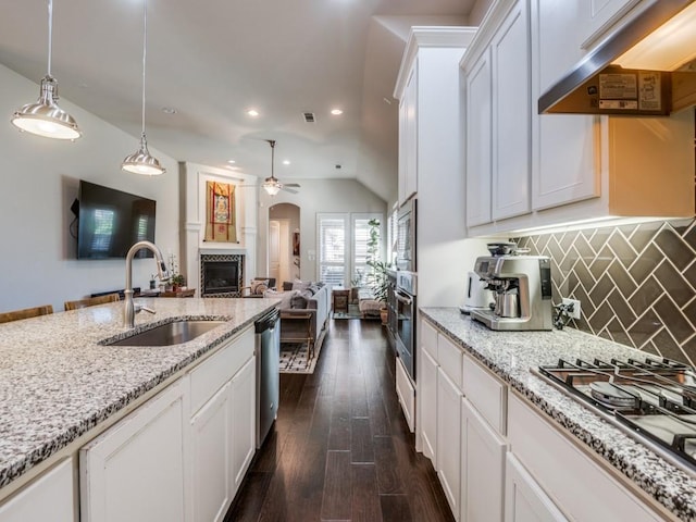 915 Enchanted Wood Dr, Arlington, TX 76005 - kitchen featuring under cabinet range hood, ceiling fan, a sink, a tile fireplace, and appliances with stainless steel finishes