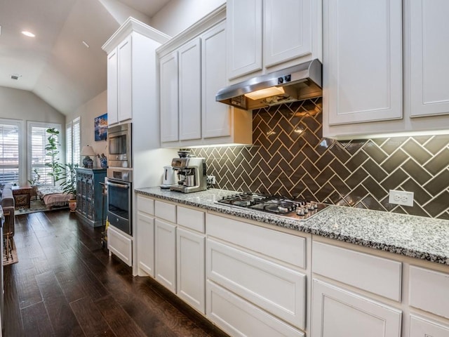 915 Enchanted Wood Dr, Arlington, TX 76005 - kitchen with stainless steel appliances, light stone counters, under cabinet range hood, vaulted ceiling, and backsplash