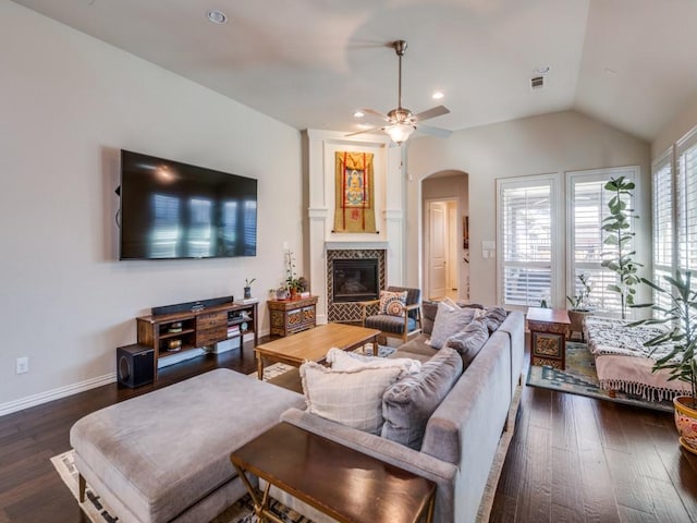 915 Enchanted Wood Dr, Arlington, TX 76005 - living area featuring dark wood-type flooring, ceiling fan, vaulted ceiling, arched walkways, and a tile fireplace