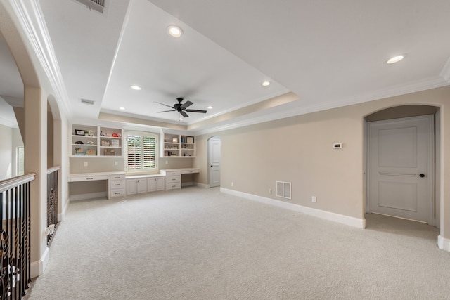 unfurnished living room with arched walkways, crown molding, light carpet, and a raised ceiling
