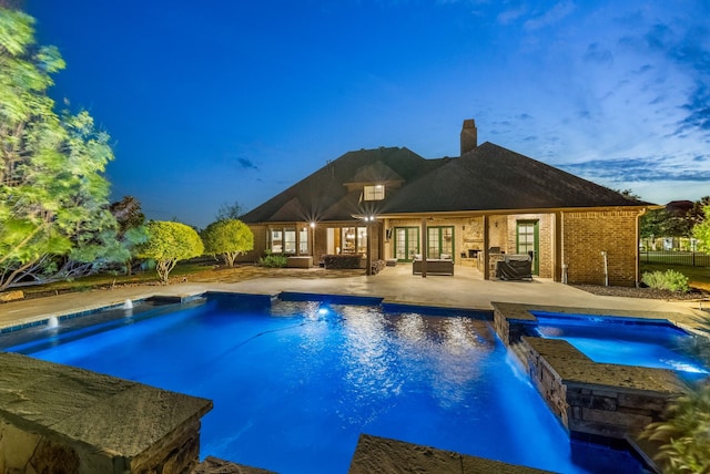 pool with an outdoor hangout area, a patio, french doors, and an in ground hot tub