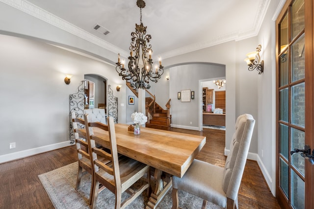 dining room featuring stairway, arched walkways, a chandelier, and visible vents