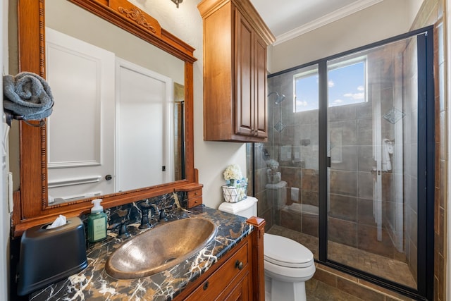 bathroom with toilet, ornamental molding, vanity, and a stall shower