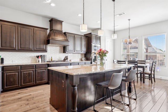 9724 Croswell St, Fort Worth, TX 76244 - kitchen featuring premium range hood, light wood finished floors, a sink, tasteful backsplash, and recessed lighting