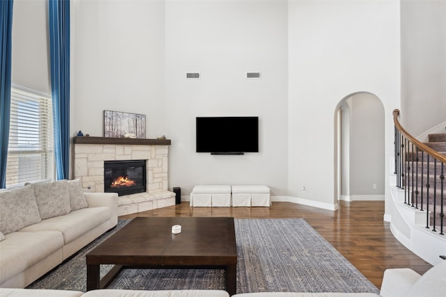 9724 Croswell St, Fort Worth, TX 76244 - living room featuring a high ceiling, wood finished floors, stairs, a stone fireplace, and baseboards