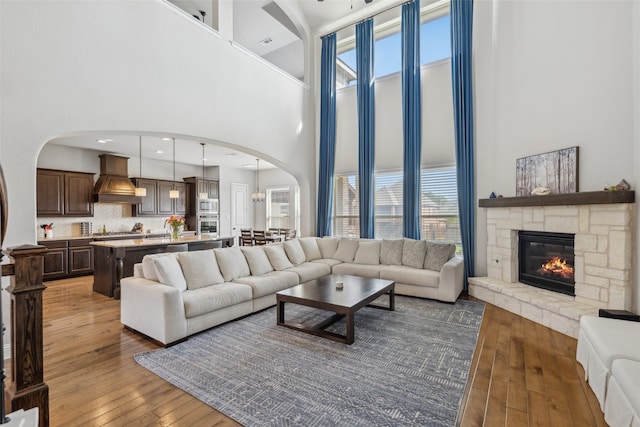 9724 Croswell St, Fort Worth, TX 76244 - living area featuring a high ceiling, arched walkways, hardwood / wood-style flooring, and a fireplace