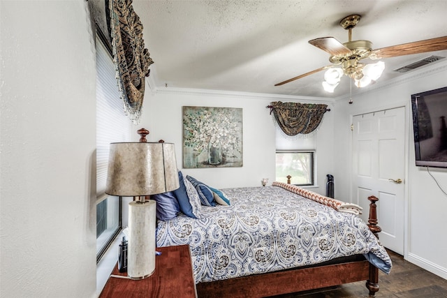 bedroom featuring wood finished floors, visible vents, ceiling fan, and crown molding