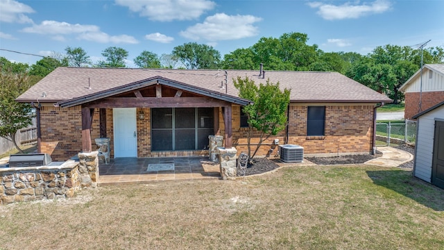 rear view of property featuring brick siding, a yard, a patio area, and fence