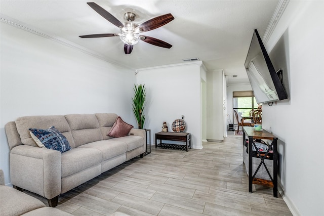 living area featuring ceiling fan, baseboards, visible vents, and ornamental molding