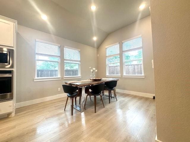 dining room featuring recessed lighting, vaulted ceiling, light wood-style flooring, and baseboards