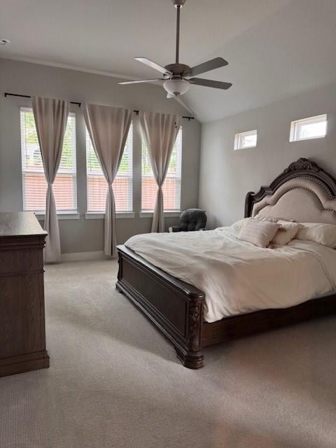 bedroom with vaulted ceiling, baseboards, light colored carpet, and multiple windows