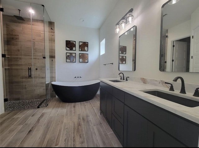 full bathroom featuring a sink, a stall shower, and wood finished floors